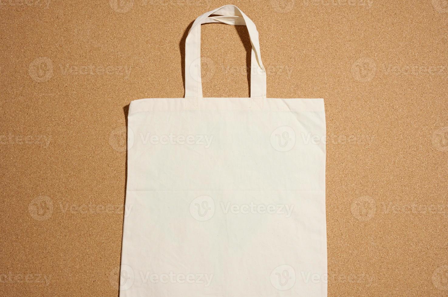 bolsa de lona beige ecológica de lino vacía para la marca sobre fondo marrón. bolsa transparente reutilizable para comestibles, maqueta. endecha plana foto