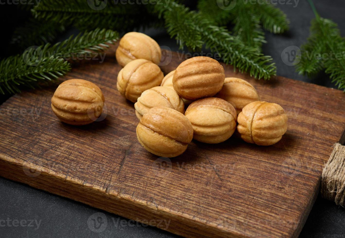 baked dessert nuts with condensed milk on a wooden board, top view photo