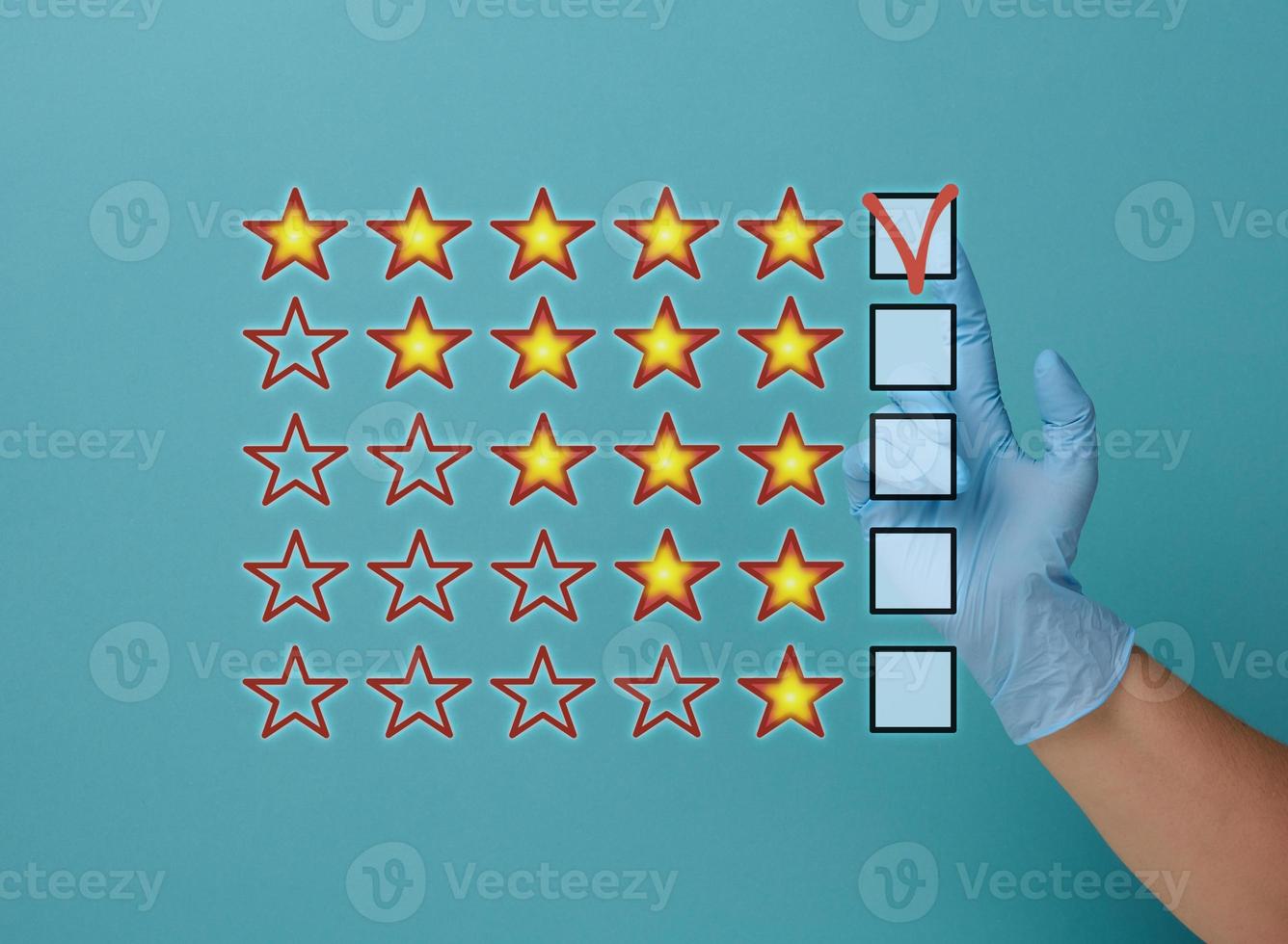 Evaluation and rating concept by voting. Best service and product. Hand in medical latex glove on blue background photo