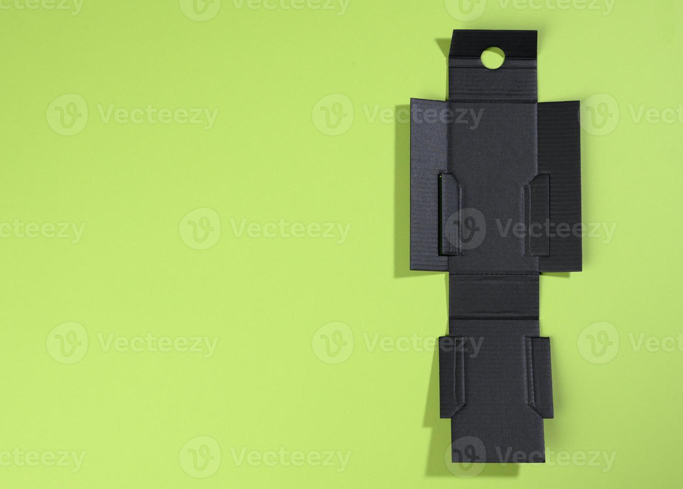 collapsible inner protective black box made of corrugated cardboard for packages with breakable goods on a green background, for perfumery photo