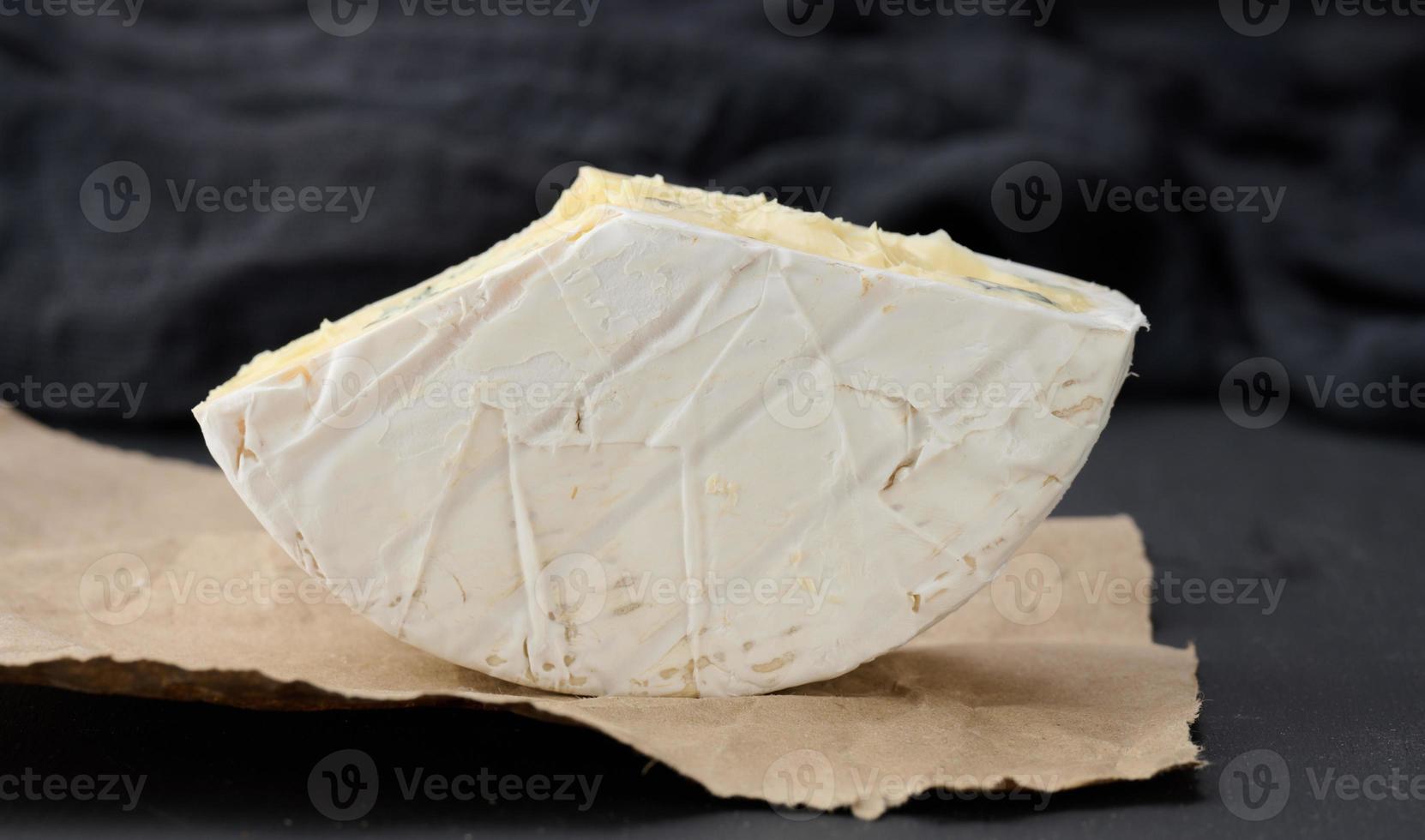 queso azul bergader sobre una tabla de madera negra, delicioso aperitivo foto