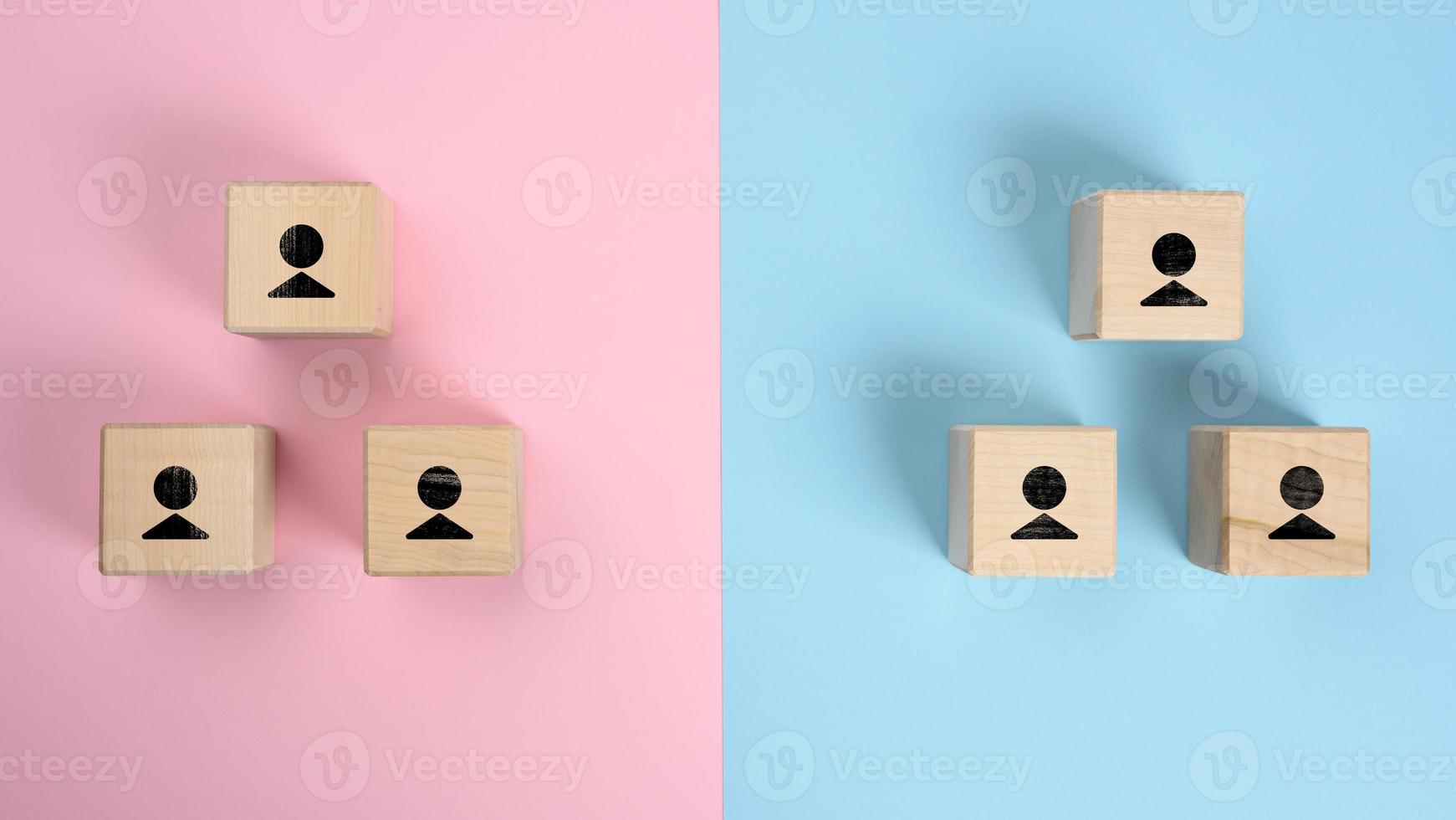 wooden blocks with figures on a pink blue background, hierarchical organizational structure of management photo