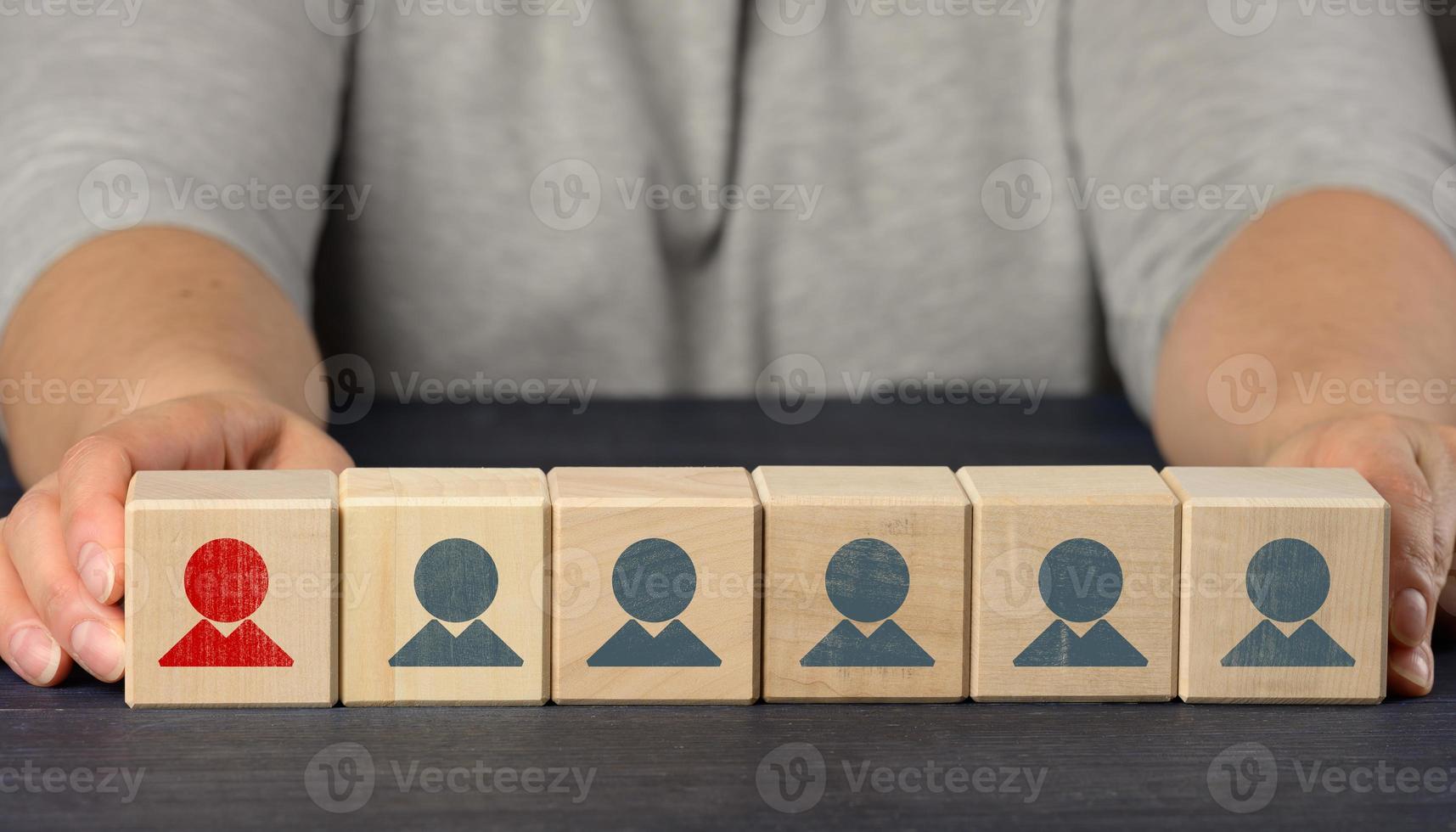 las manos femeninas sostienen cubos de madera con figuritas. concepto de búsqueda de empleados, contratación de personal foto