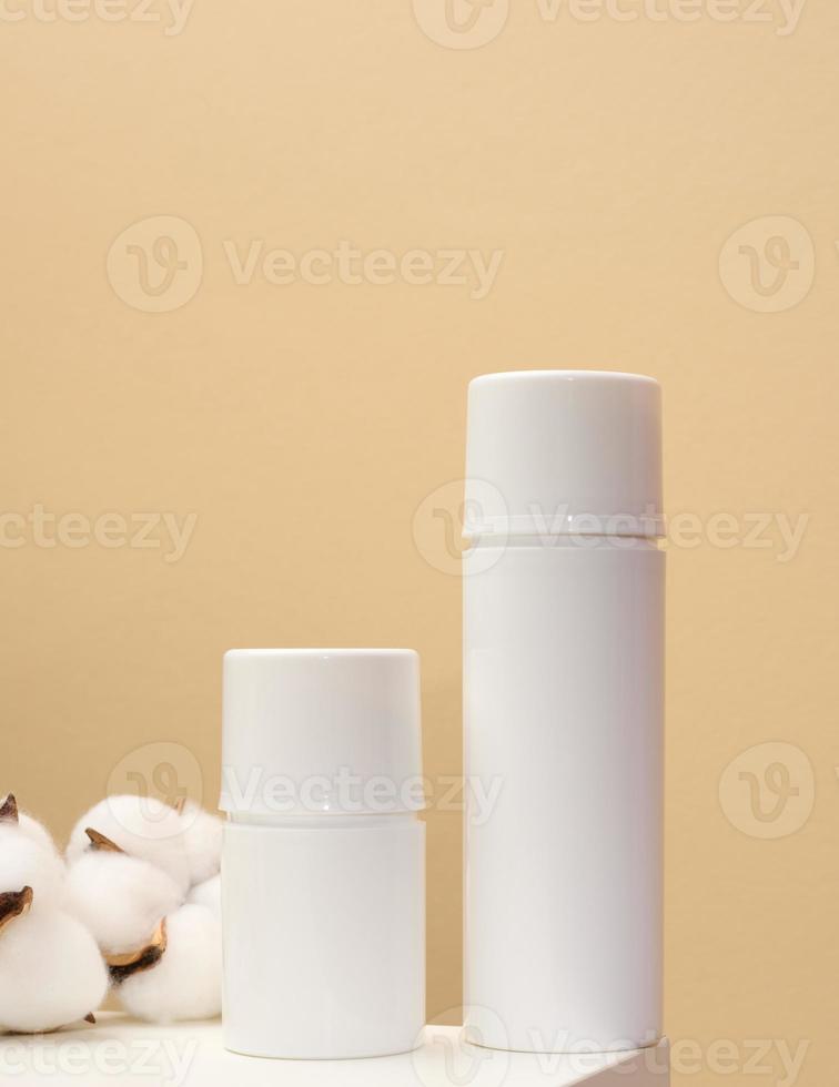 botella de plástico blanca vacía sobre un fondo beige. productos cosméticos para branding gel, crema, loción, champú. maqueta de cosmética ecológica foto