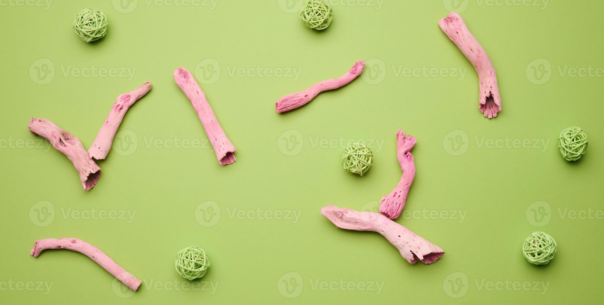 abstract green background with pink plant roots and green wicker balls, top view photo