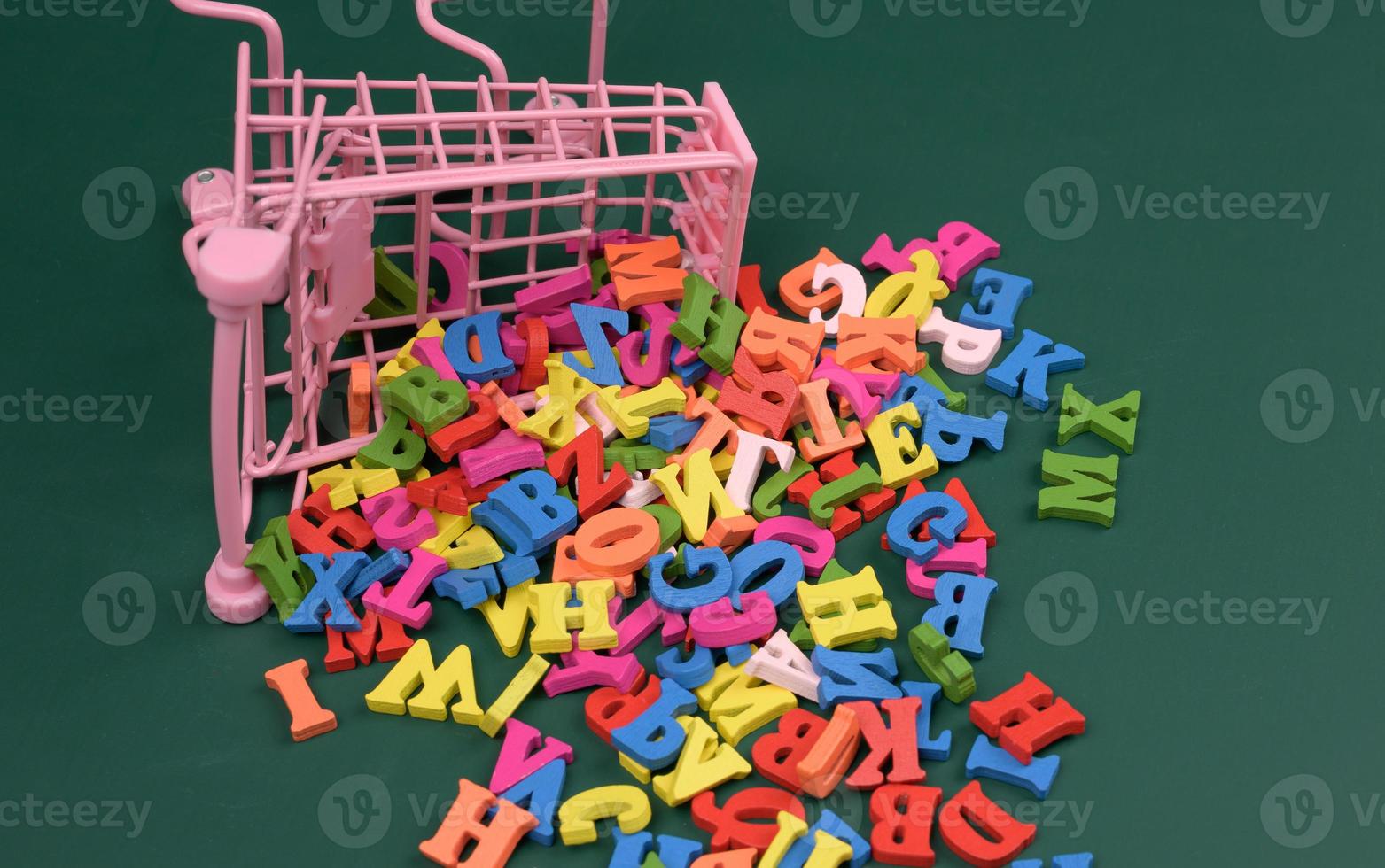 scattered multicolored letters of the english alphabet from a miniature shopping cart photo