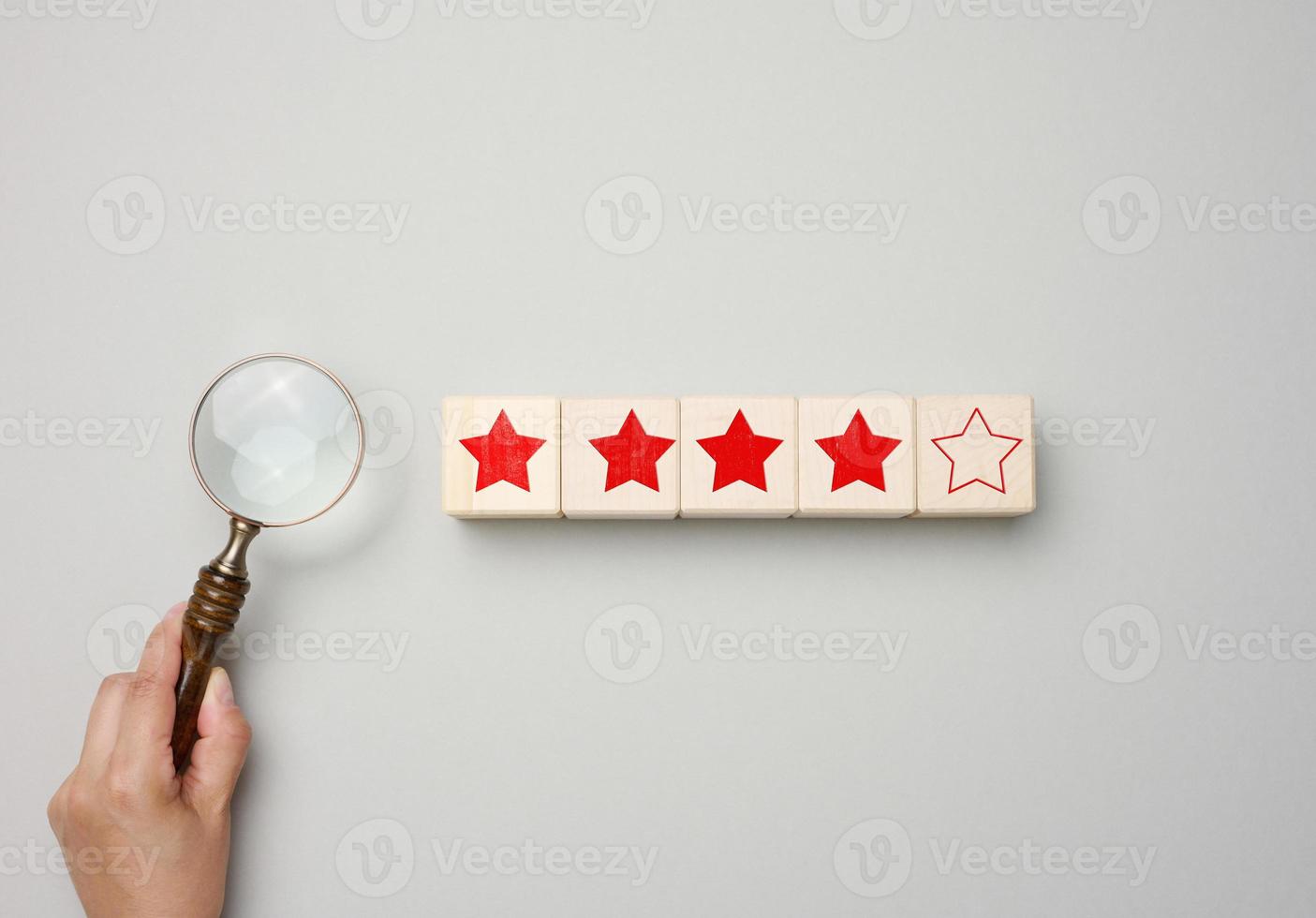 five red stars and a hand with a plastic magnifier on a green background.  Evaluation of the quality of services and goods, high rating Stock Photo -  Alamy