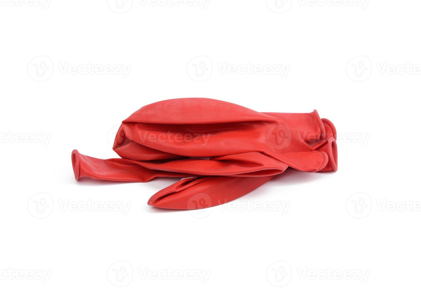 pile of deflated rubber red balls isolated on white background photo