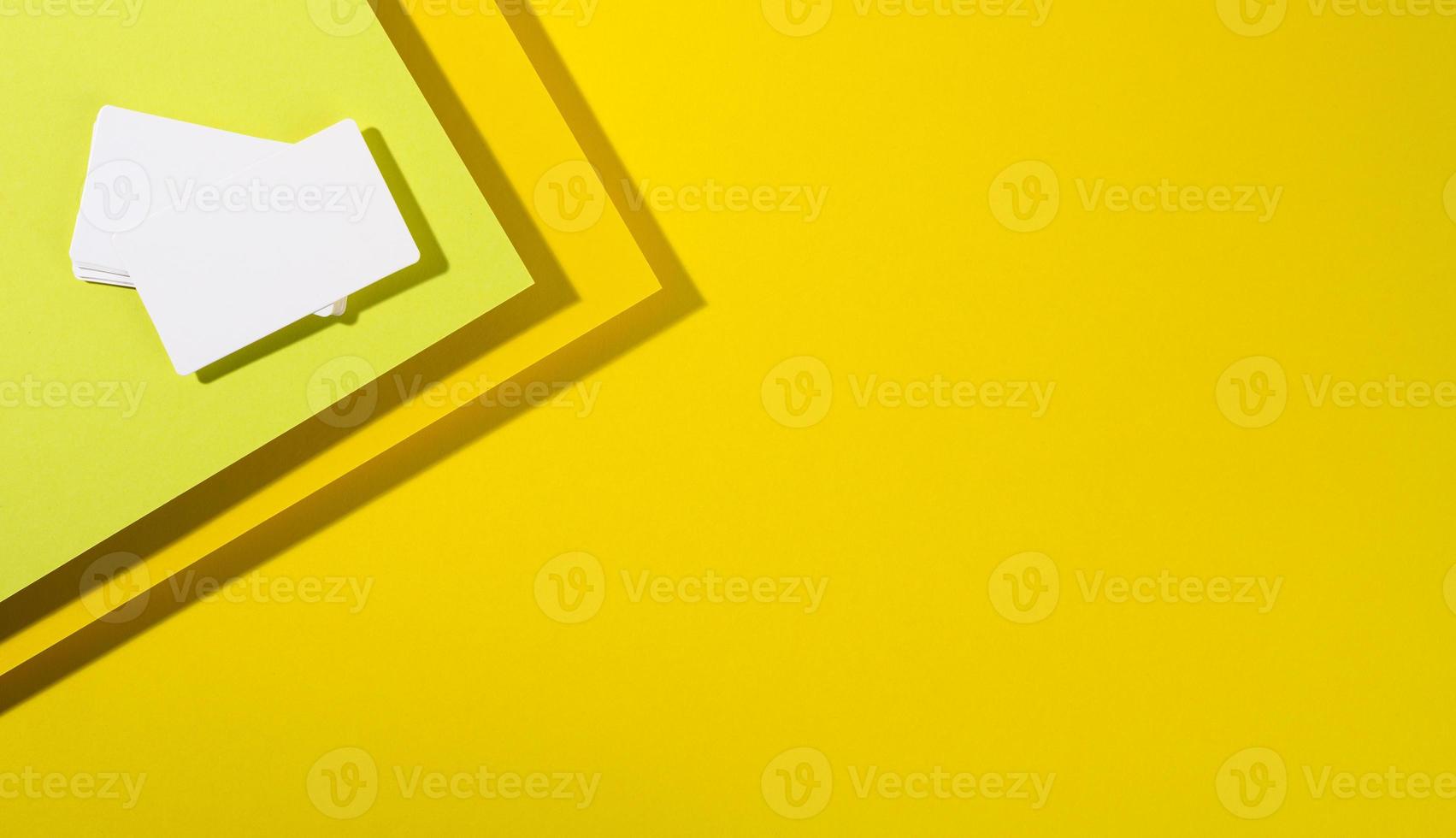 tarjeta de visita rectangular blanca en blanco sobre fondo amarillo creativo de hojas de papel con sombra foto