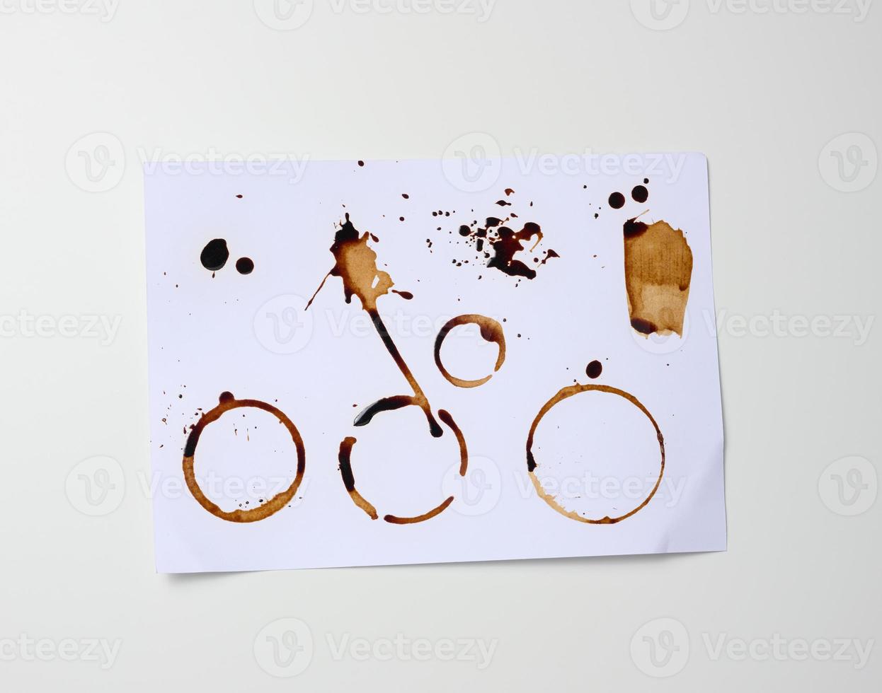 hoja blanca de papel con huellas marrones del fondo de la taza con café, manchas y salpicaduras foto
