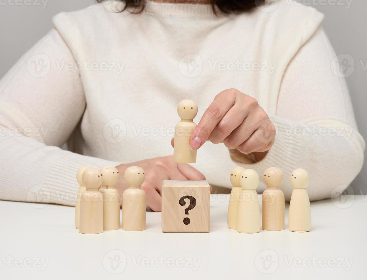 Woman keeps the red wooden figurine separate from the group. Career growth concept, unique person. photo