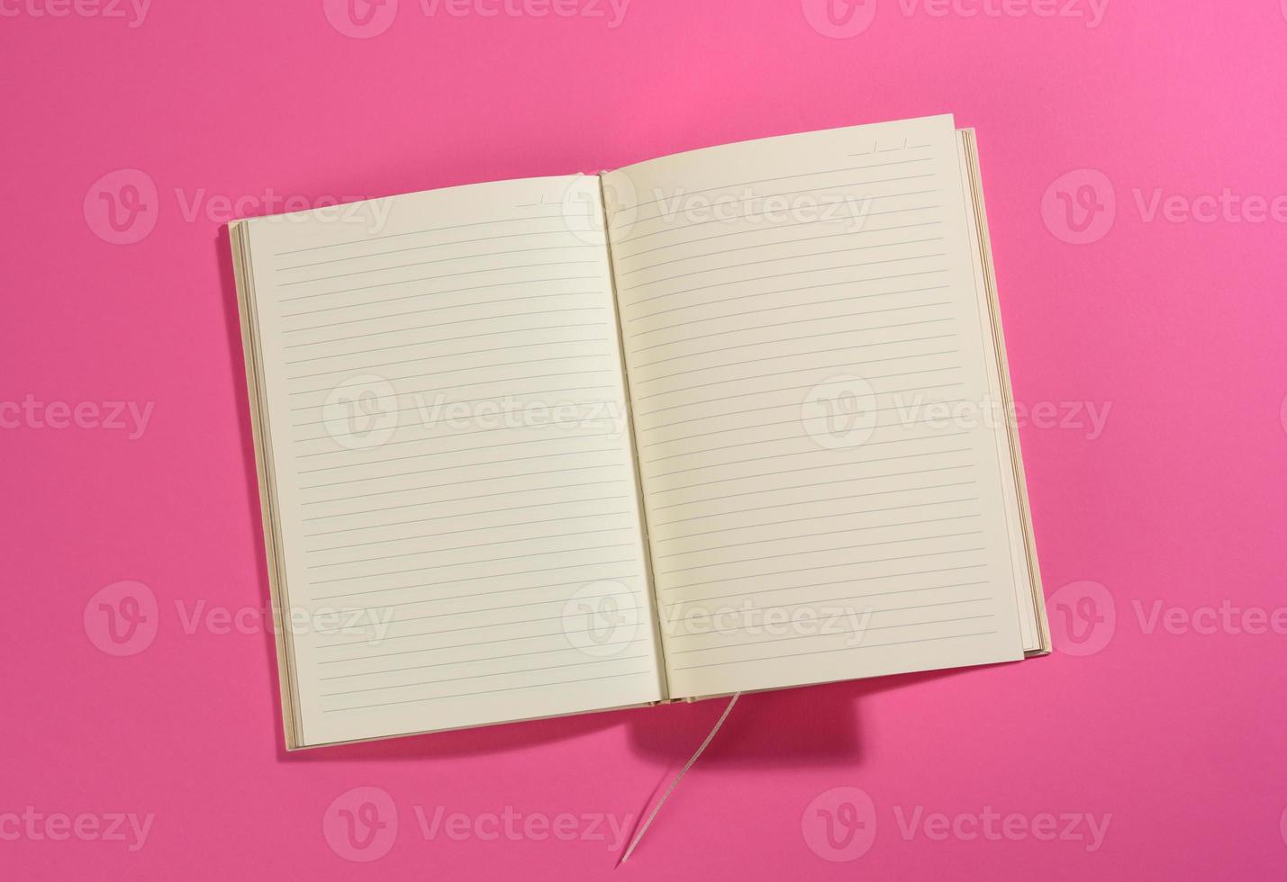open notebook with blank white sheets on pink background photo