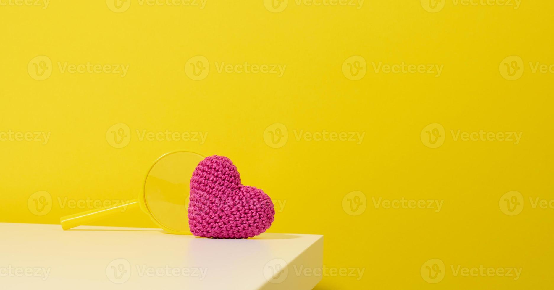 red heart and magnifier on a white table. Finding a donor organ photo