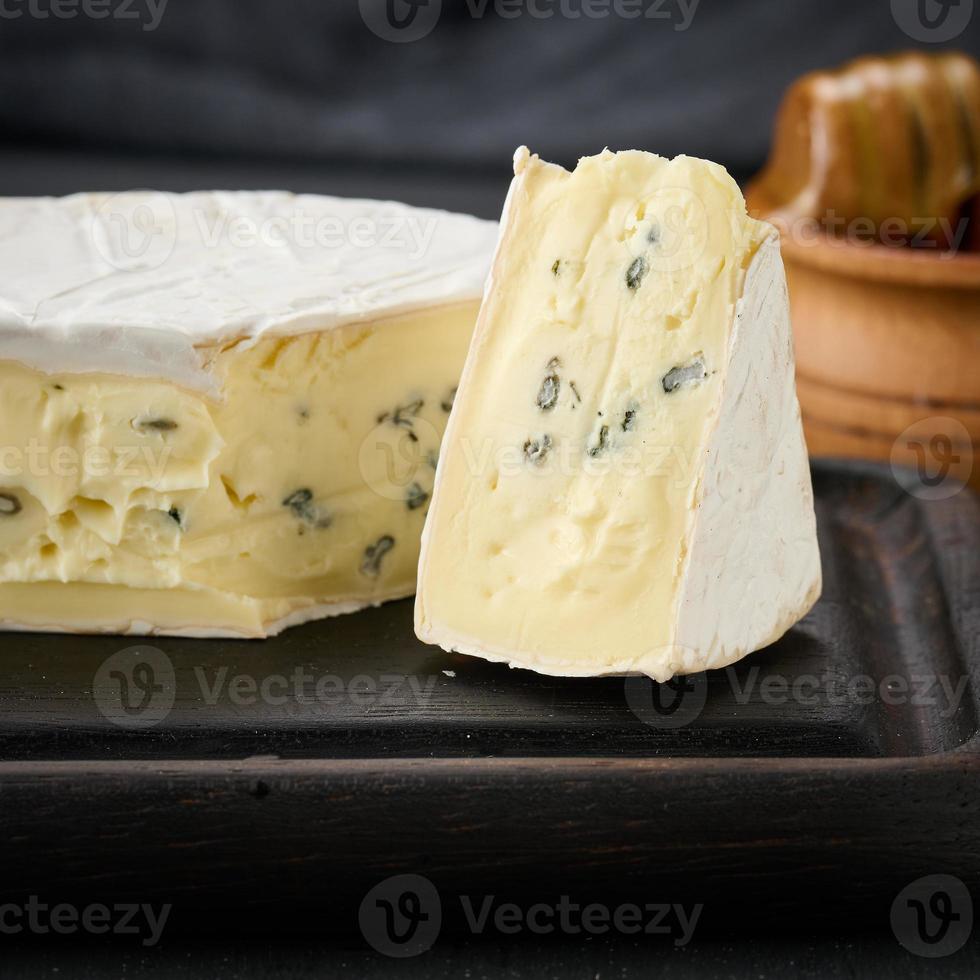 queso azul bergader sobre una tabla de madera marrón, delicioso aperitivo foto