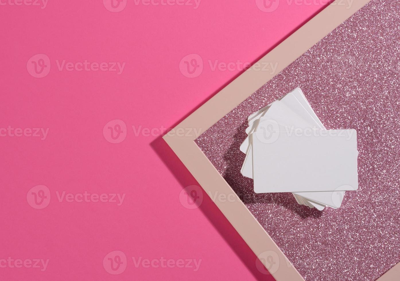 la tarjeta de visita rectangular en blanco se encuentra sobre un moderno fondo rosa hojas de papel con una sombra foto