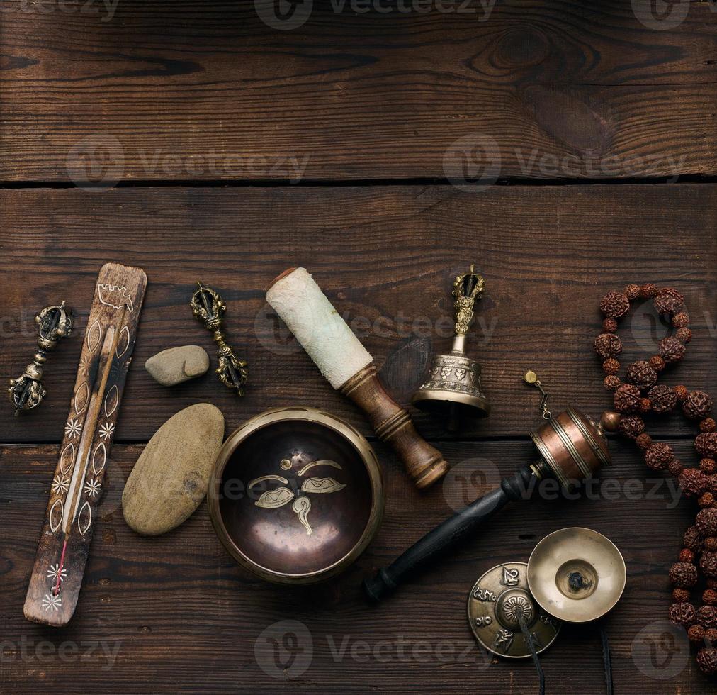 Cuenco tibetano de cobre para cantar con una chapaleta de madera, objetos para la meditación y la medicina alternativa, vista superior foto