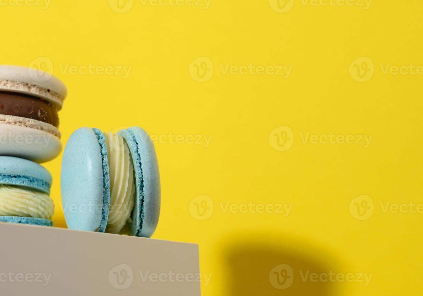 baked round macarons on a yellow background, delicious dessert photo