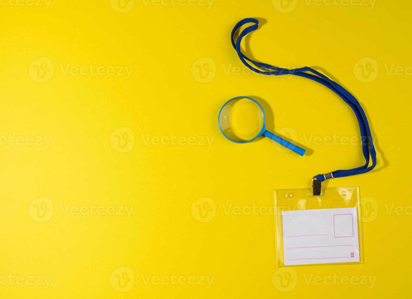 transparent plastic badge on a blue lanyard on a yellow background photo