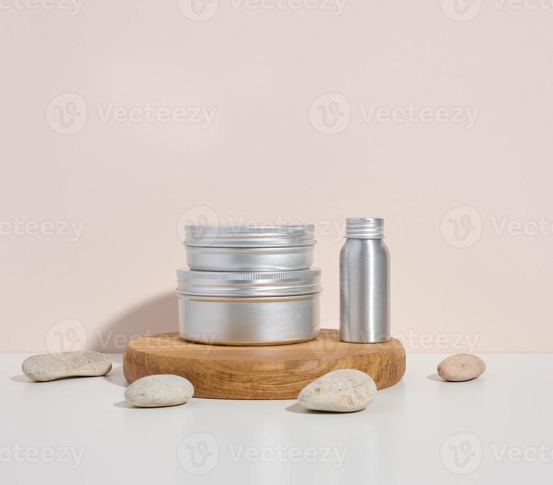 botella de metal plateado vacía para cosméticos en mesa blanca. envases para crema, gel, suero, publicidad y promoción de productos. foto