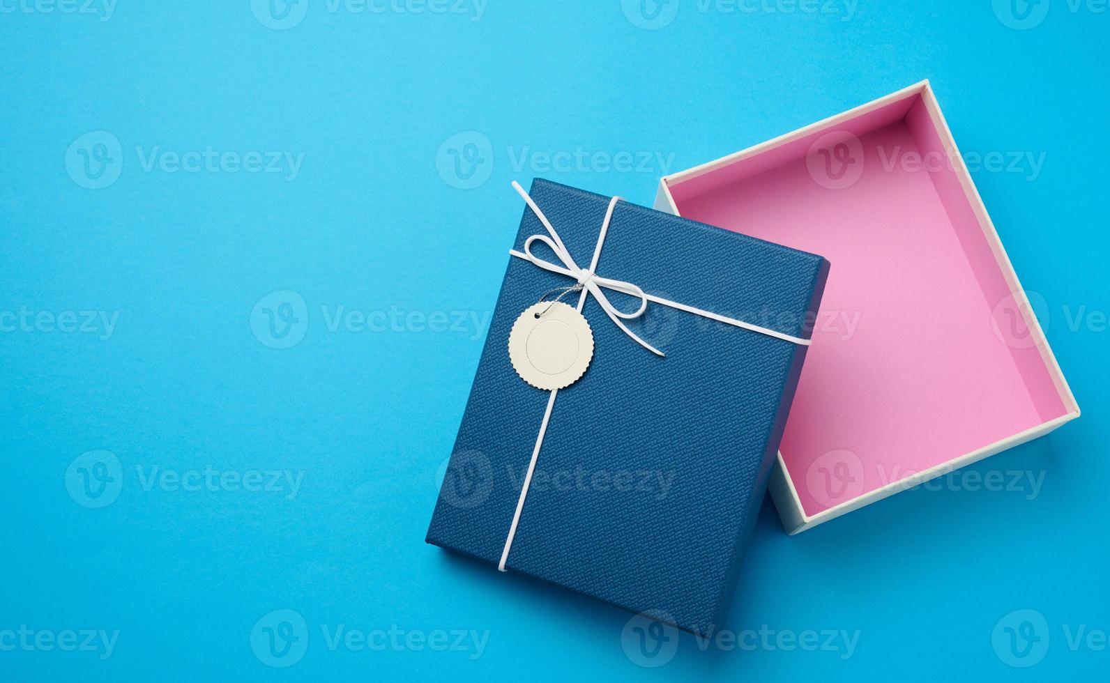 Empty open rectangular gift cardboard box on blue background, top view photo