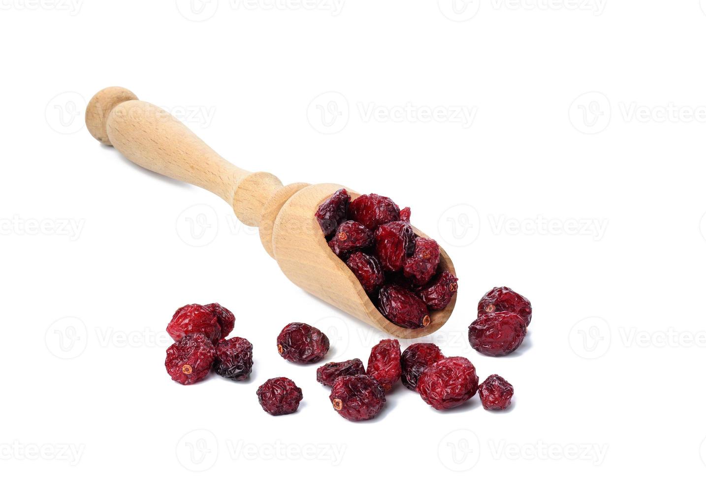 bunch of dried cranberries in a wooden spoon on a white background. Delicious berry photo