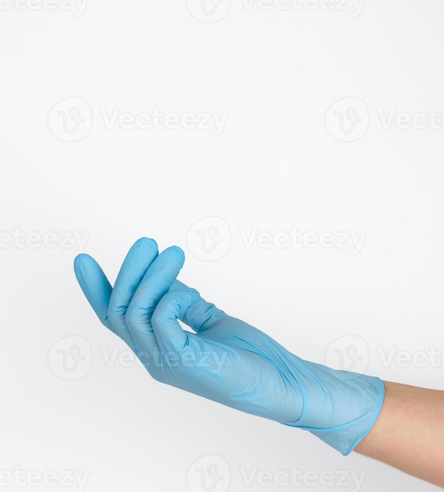 Doctor's hand in a blue medical glove holds an object on a white background. Copy space, hold any object photo