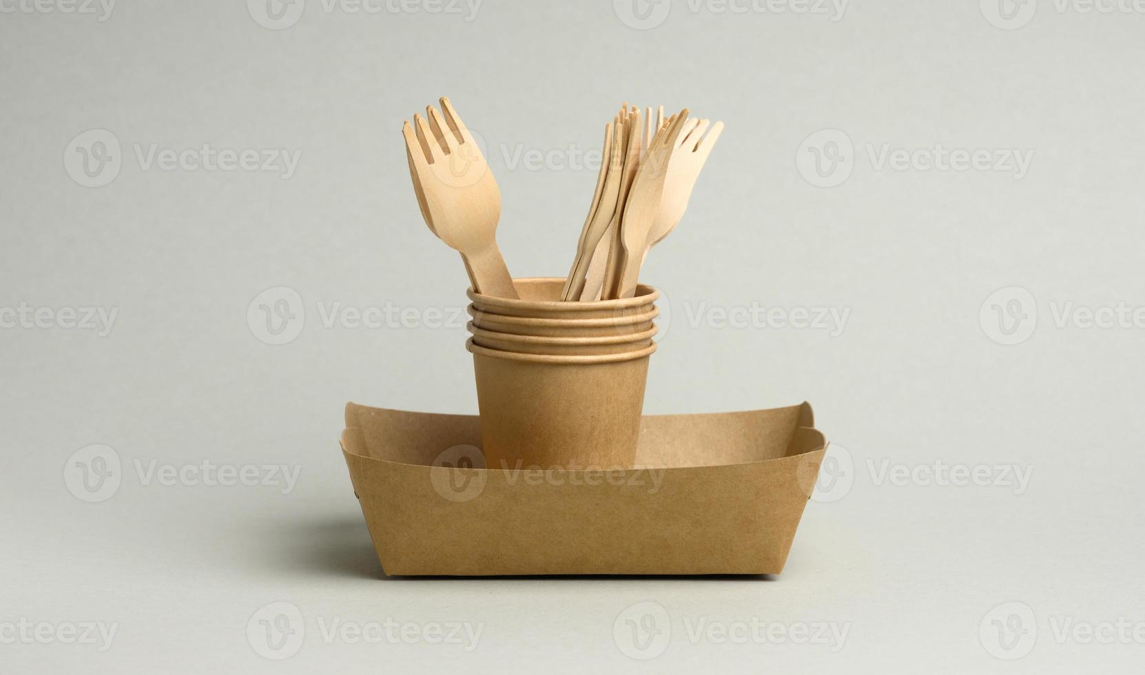 disposable brown paper cups, rectangular plates and wooden forks on a