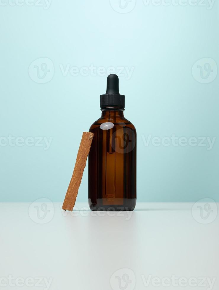 Brown glass bottle with a pipette on a blue background photo