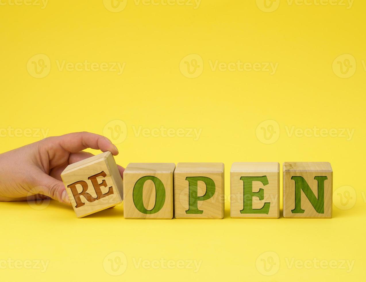 hand holds a stack of wooden cubes on the reopen inscriptions. The concept was opened after restructuring, renovation photo