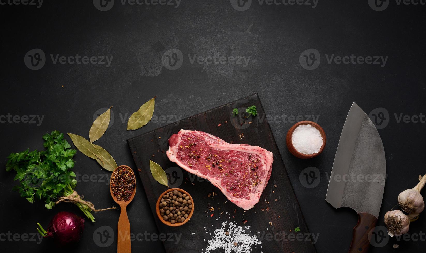 fresh raw piece of beef meat, striploin steak on a black background, top view. Marbled piece of meat New York photo