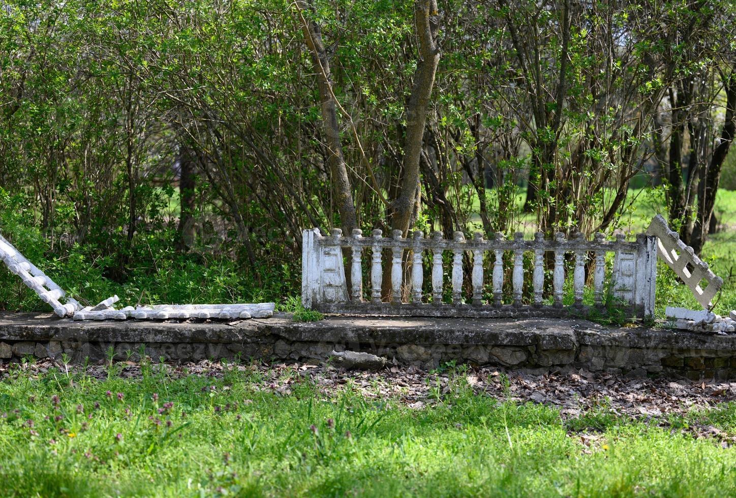 broken concrete decorative fence in a public park, vandalism photo