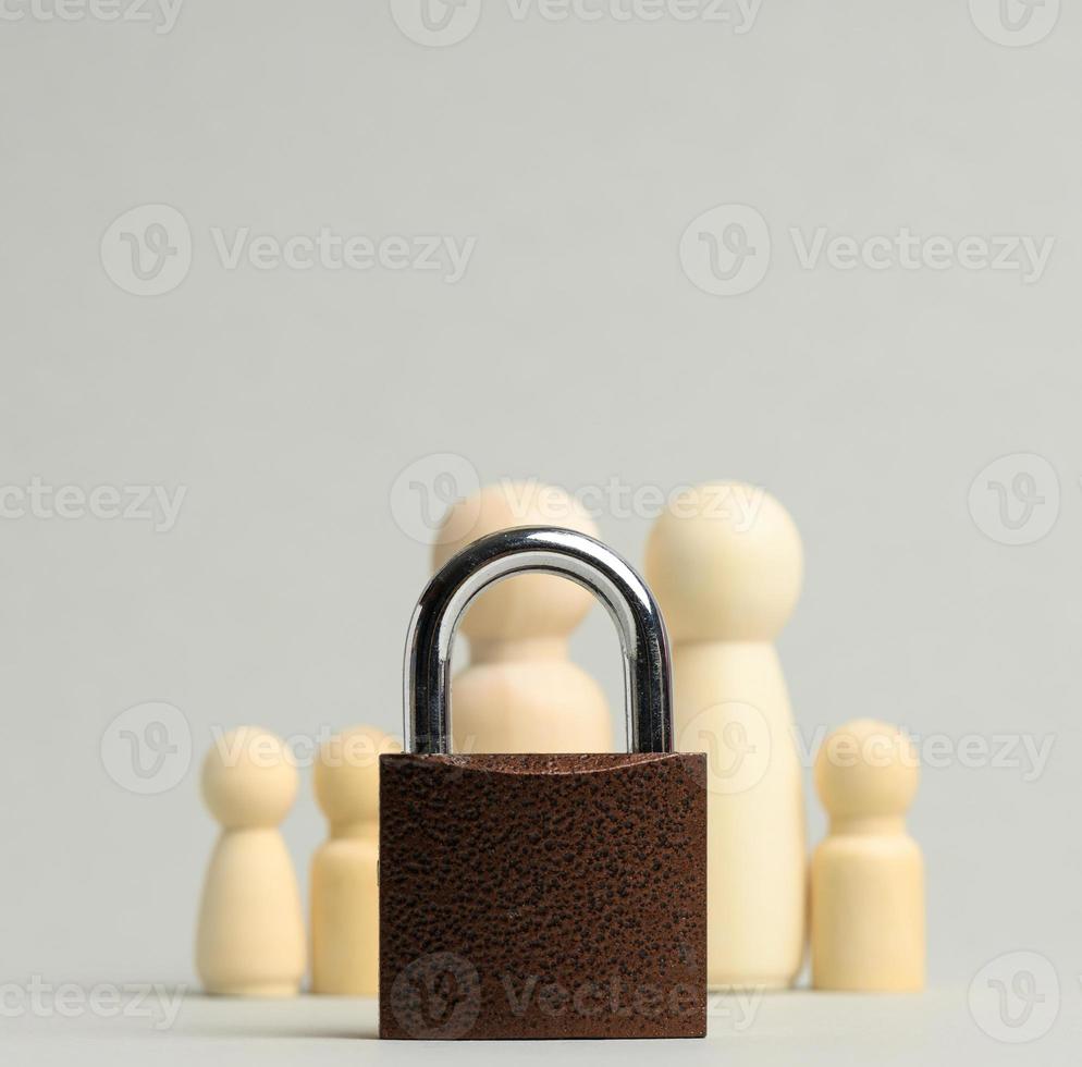 metal lock and a family of wooden figures on a gray background. Security concept, personal data photo