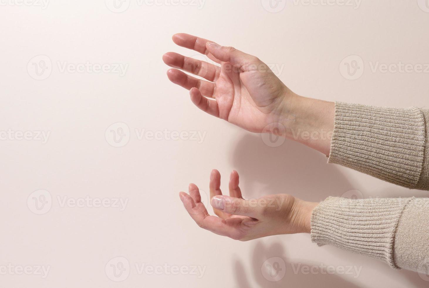 two female hands hold any object on a beige background. Product presentation, cosmetics photo