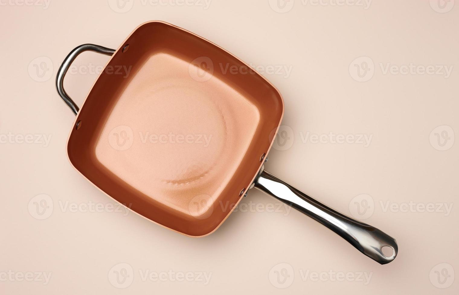 new copper deep frying pan on a beige background, top view photo