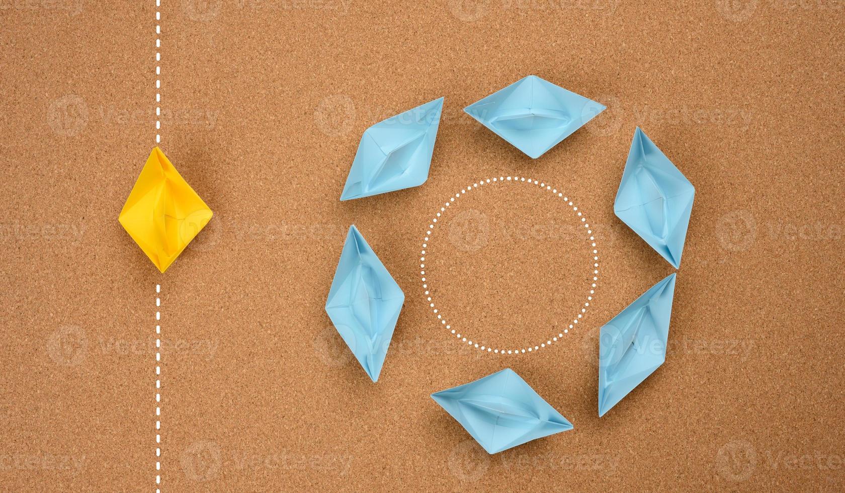 a group of blue boats floats in a circle and one floats along a straight path. The concept of thinking outside the box photo