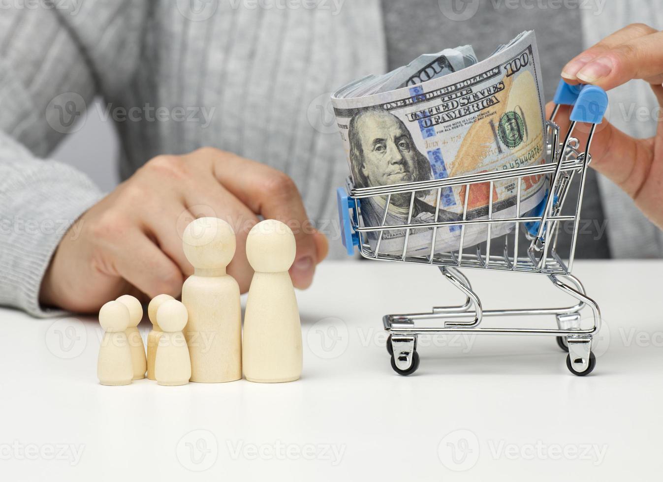 woman sits at a table and a miniature cart with US dollars. Concept of savings, sale, tax photo