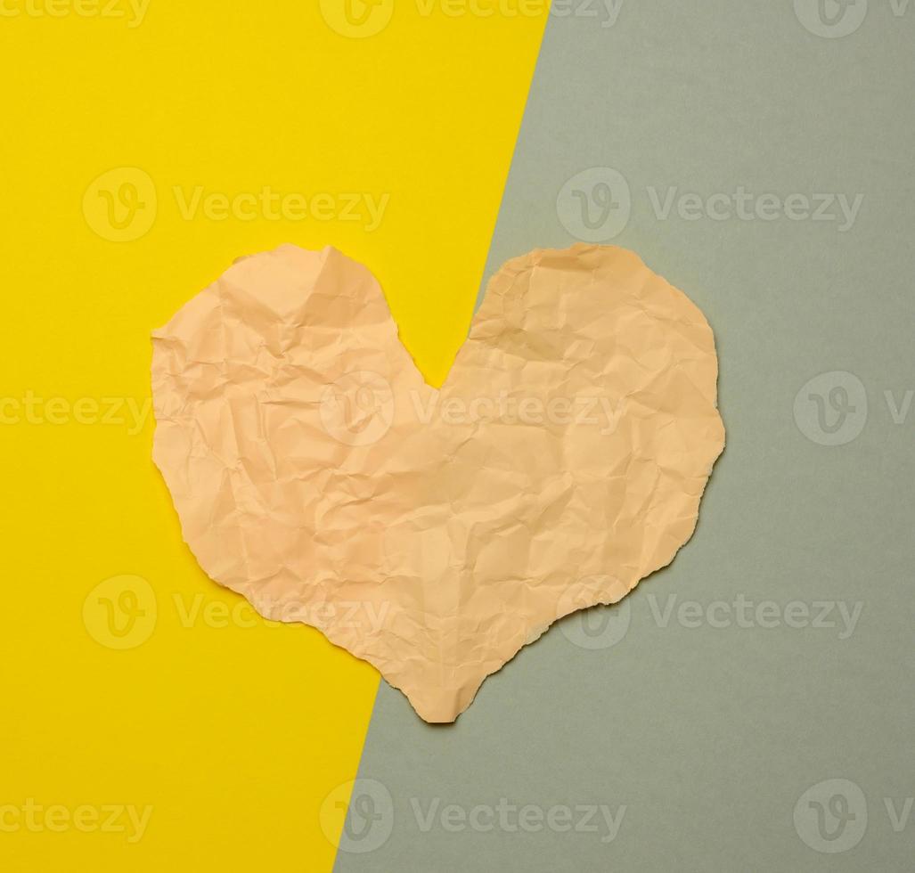 heart made of torn paper on a gray-yellow background photo