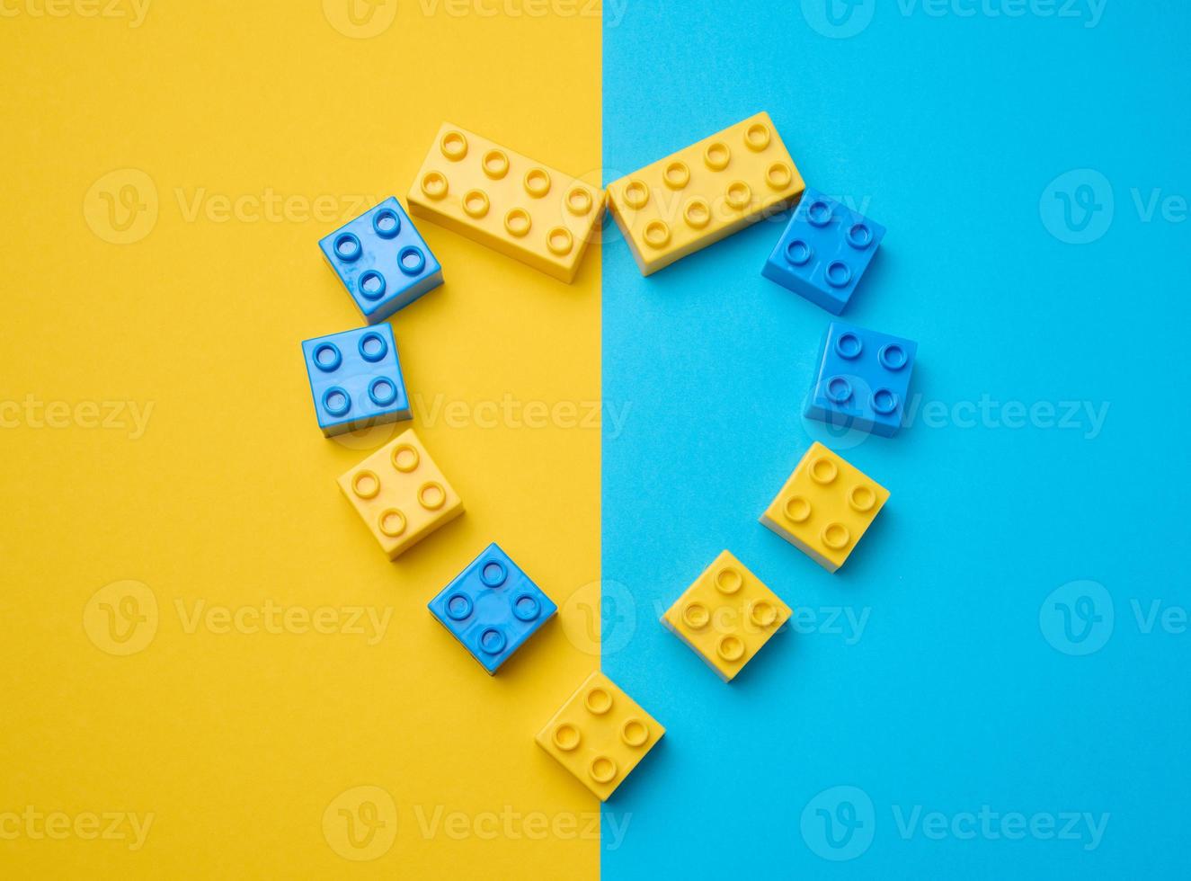 Plastic yellow-blue details of the children's designer in the shape of a heart. Children's educational game, top view photo