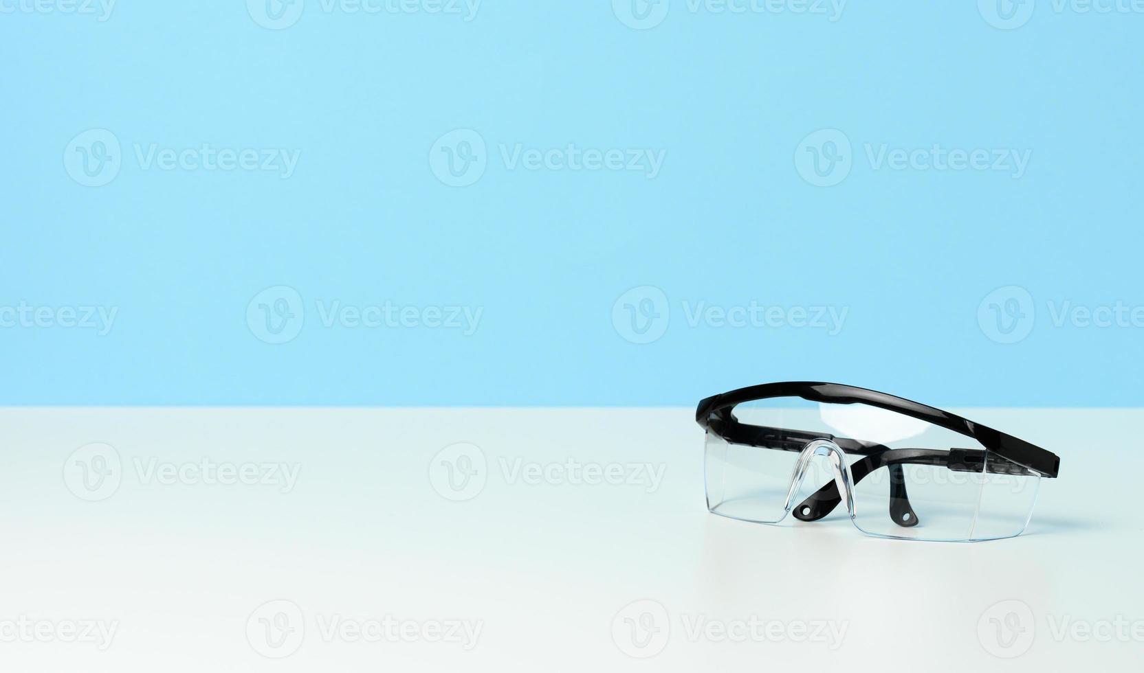 gafas médicas de plástico sobre mesa blanca, equipo de protección personal foto