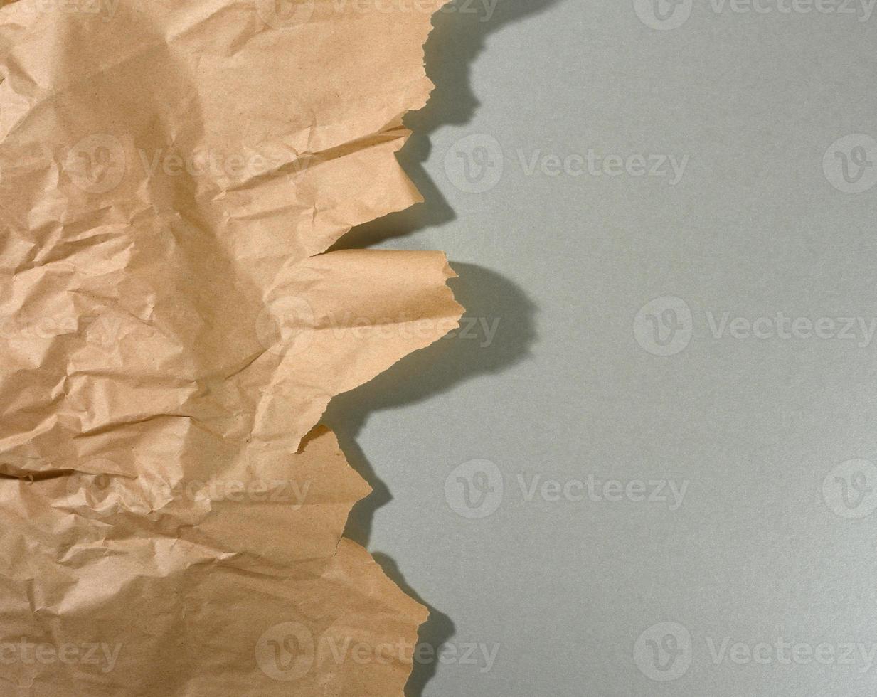 trozo de papel marrón menta con bordes rasgados y sombra sobre fondo gris. telón de fondo creativo abstracto para el diseñador foto