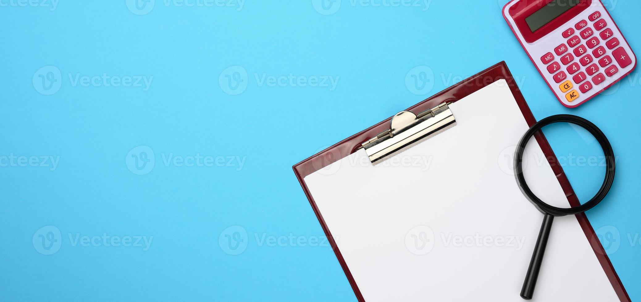 pink calculator, folder with blank white sheets and black magnifier on a blue background. Banner for business photo