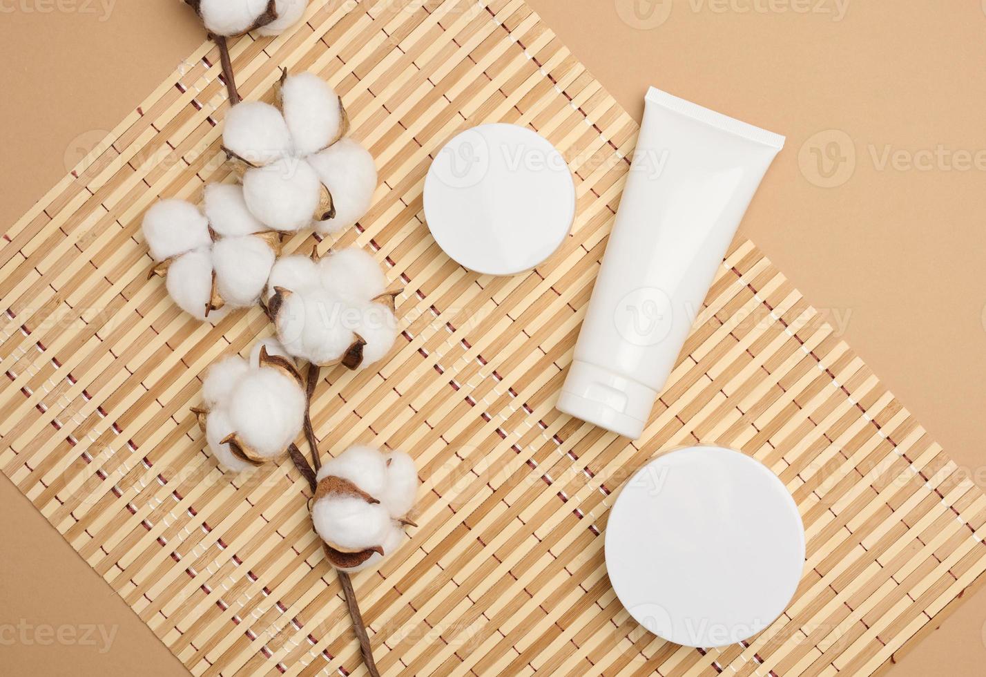 tarro y tubos de plástico blancos vacíos para cosméticos sobre un fondo beige. embalaje para crema, gel, suero, publicidad y promoción de productos, maqueta, vista superior foto