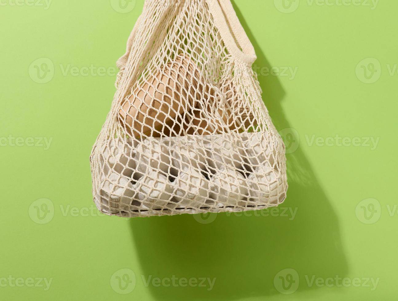 textile bag with paper cups hanging on a green background. Refusal from plastic bags photo