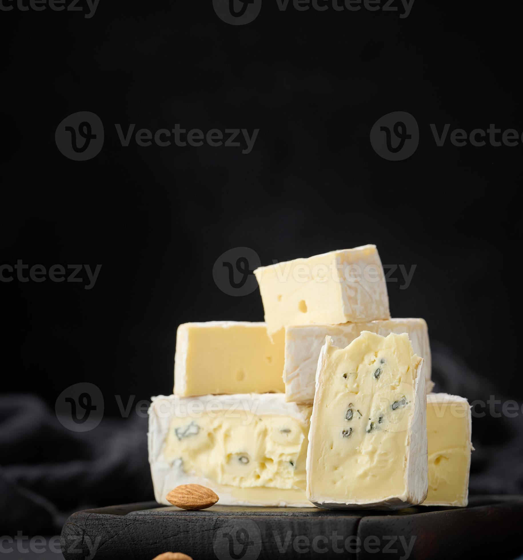 brie and bergader blue cheese on a brown wooden board, delicious snack ...