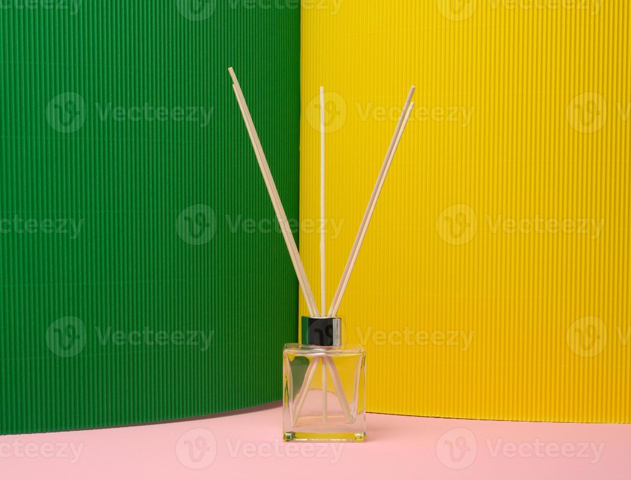 glass flask and wooden sticks, aroma lamp on colored background photo