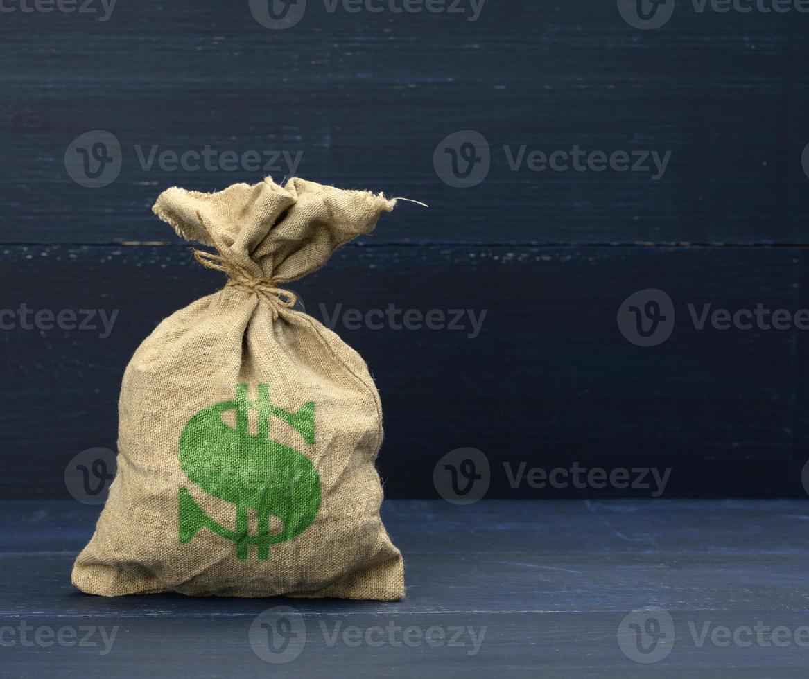 brown full canvas bag with dollar symbol on blue background. Savings, loan and investment concept photo