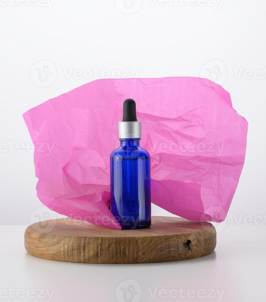 blue glass bottle with pipette for cosmetics, oils and serum. Advertising and product promotion photo
