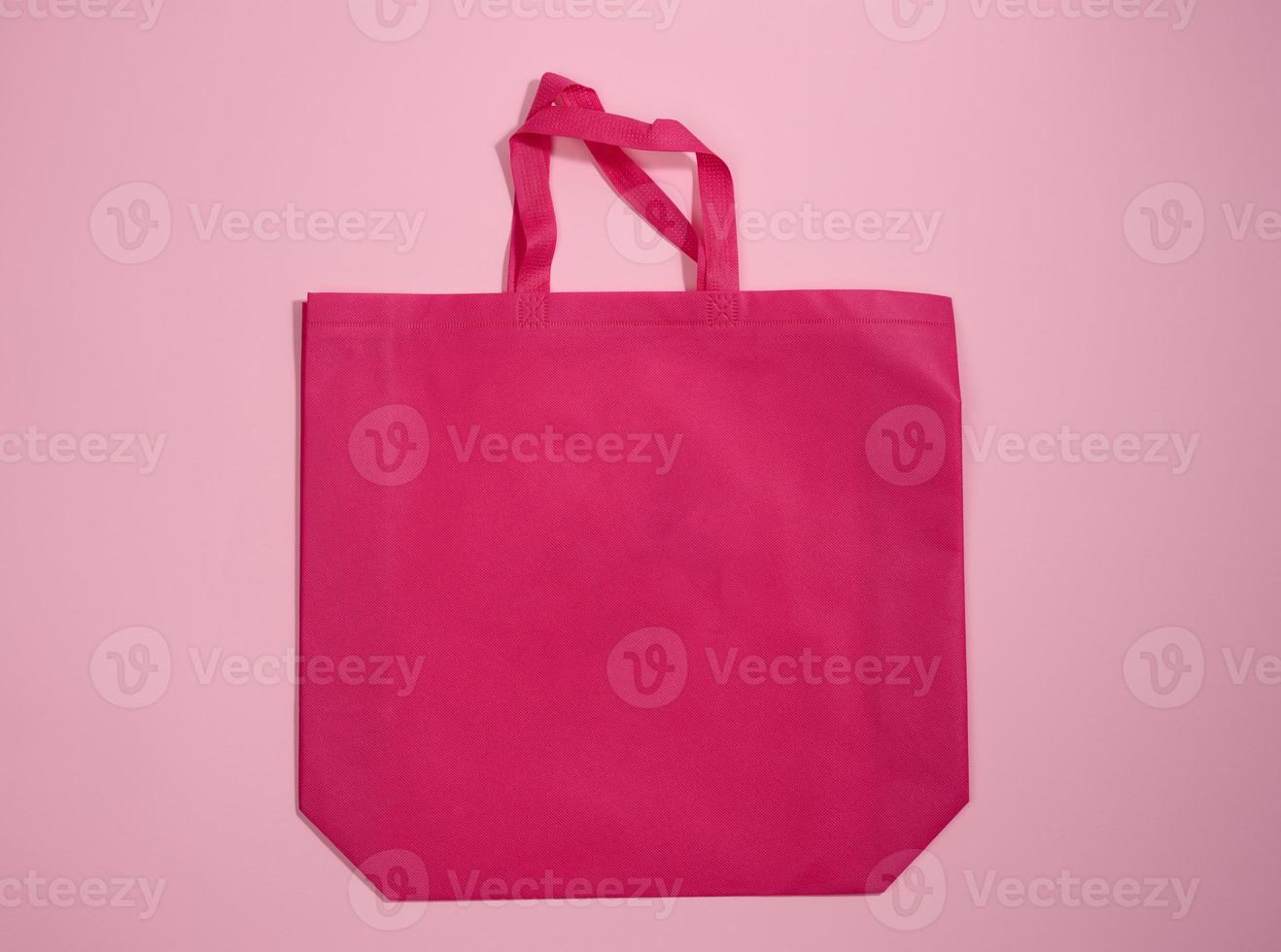 empty viscose eco friendlypink canvas tote bag for branding on a pink background. Clear reusable bag for groceries, mock up photo