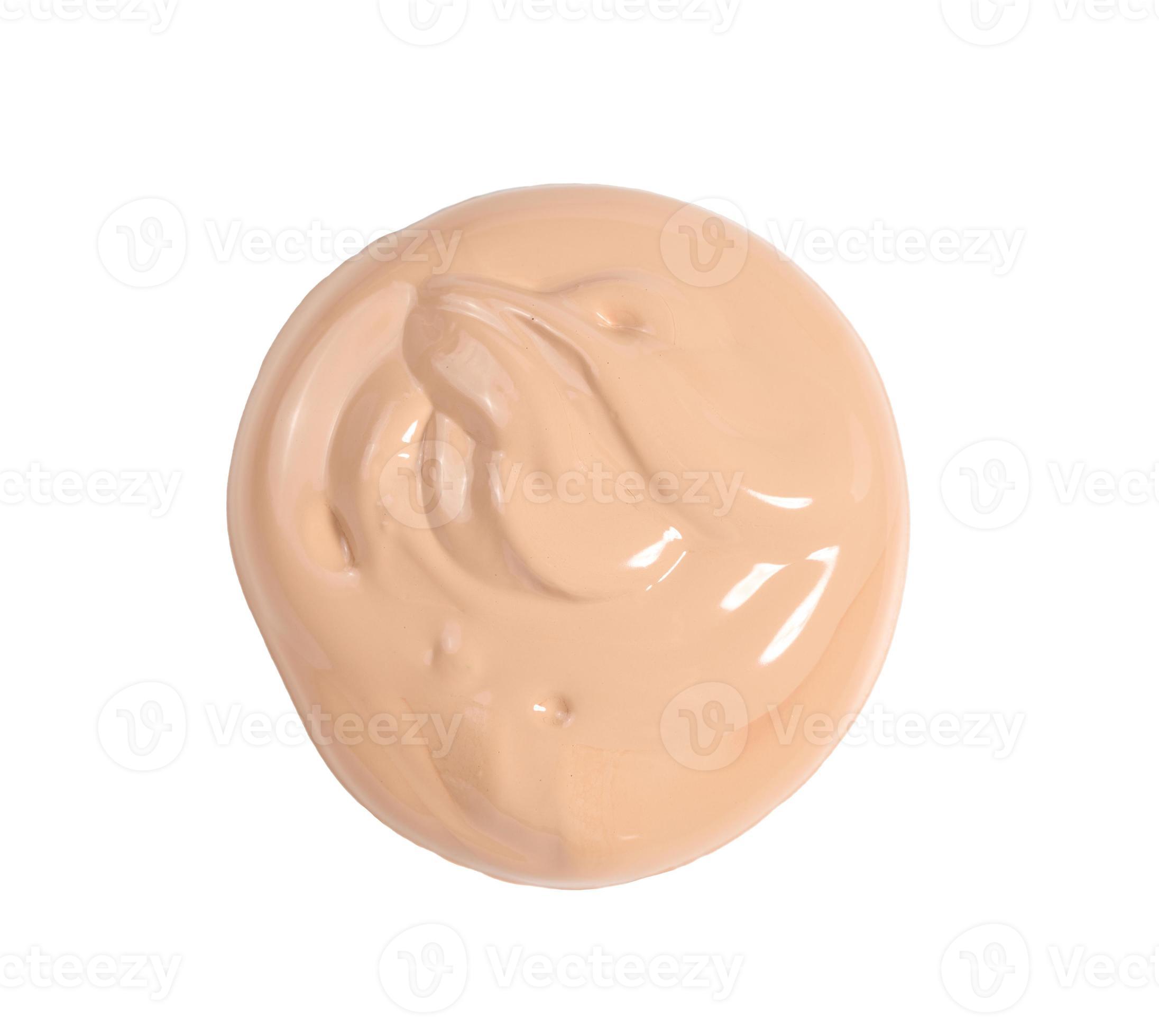 round swatch of light brown face cream on white background, top view