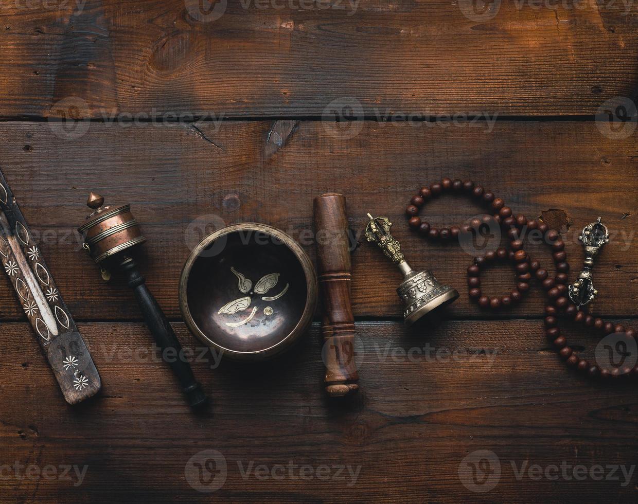 Tibetan singing copper bowl with a wooden clapper , objects for meditation and alternative medicine, top view. Plunging into a trance photo